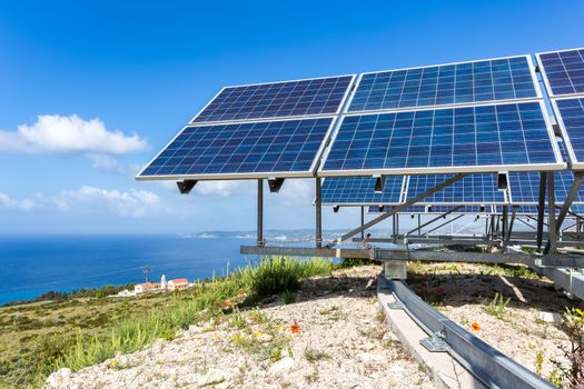 Many blue solar collectors near sea and monastry at coast in Kefalonia Greece