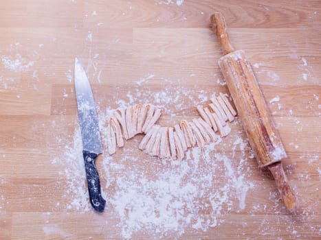 Preparation homemade pasta on wooden table.