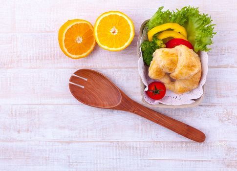 Clean food breakfast croissant and salad on wooden table.