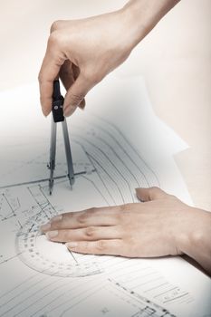 Hands of engineer working on a construction plan