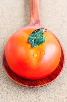 The giant red tomato with wooden spoon. - Healthy food concept.