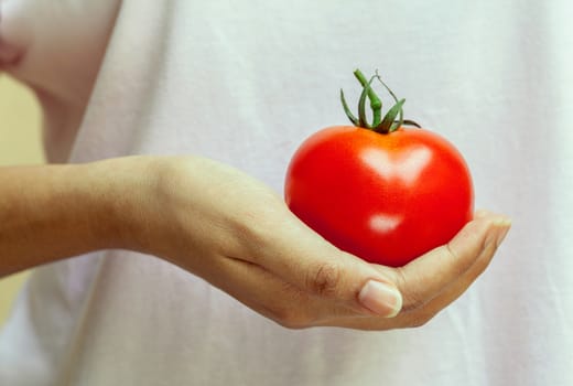 The Girl holding tomato. - Healthy food concept.