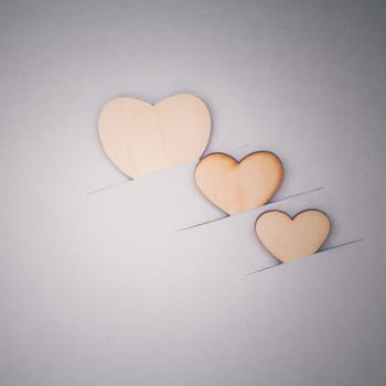 The wooden hearts on cardboard background. - Concept for love and wedding .