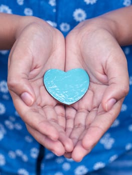 Girl holding wood shape of heart . Concept for giving love.