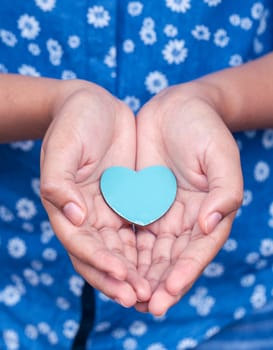 Girl holding wood shape of heart . Concept for giving love.