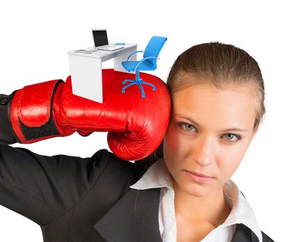Businesswoman in boxing gloves with office table and chair looking at camera on isolated white background