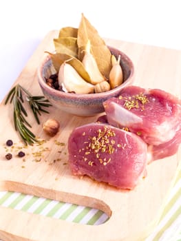 Row tenderloin with herbs on cutting board. - Steak preparing and ingredients.