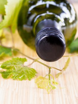 Wine bottle with vine and wine cork put on the board.