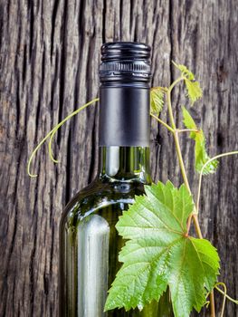 Wine bottle with vine and wine cork put on the board.