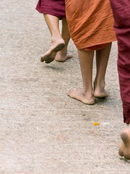 Foots of ascetic Buddhist monk walking at the way to  Kyaikhtiyo.