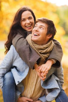 love, relationship, family and people concept - smiling couple hugging in autumn park