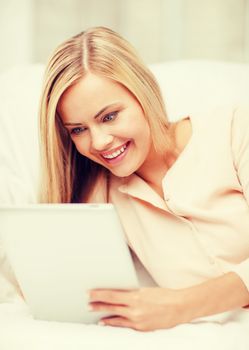 leisure and education concept - smiling woman lying on the couch with tablet pc