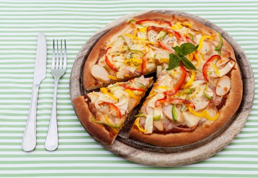 Delicious homemade pizza with ham and vegetables.