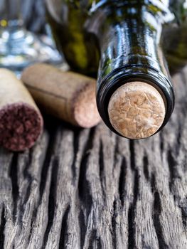 Bottle of wine and corks on wooden table. - Macro shot with selected focus.