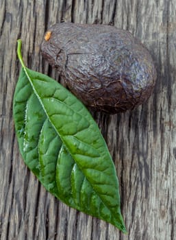 Fresh avocado with leaf put on wooden board - in macro shot.