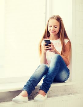 education, school, technology and internet concept - little student girl with smartphone at school