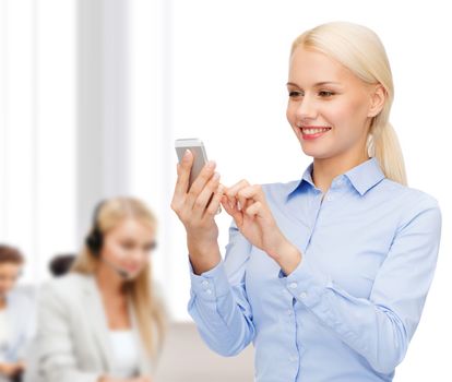 business, technology, service and education concept - smiling young businesswoman with smartphone in office