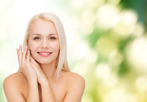 health and beauty concept - face and hands of happy woman