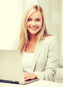 business and technology concept - businesswoman with laptop in office