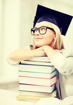 business and education concept - happy student in graduation cap with stack of books