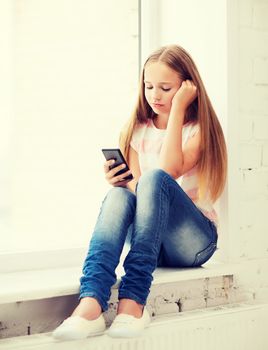 education, school, technology and internet concept - little student girl with smartphone at school