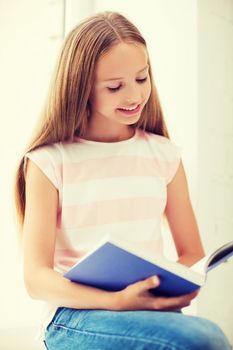 education and school concept - little student girl studying at school