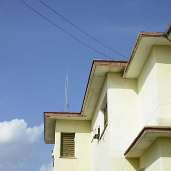 Brightly lit exterior of a Caribean apartment building and blue sky