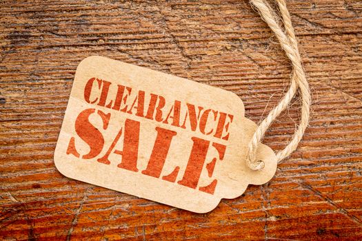 clearance sale sign a paper price tag against rustic red painted barn wood