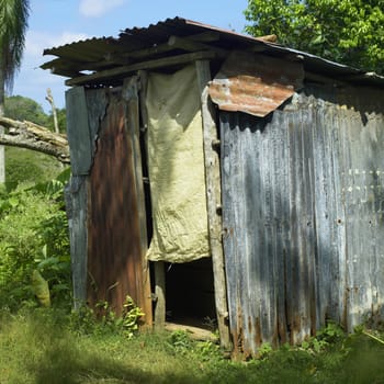 Rudimentary shack with fabric door in a tropical location