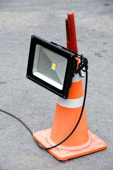 LED energy saving industrial flood light mounted on orange striped rubber cone