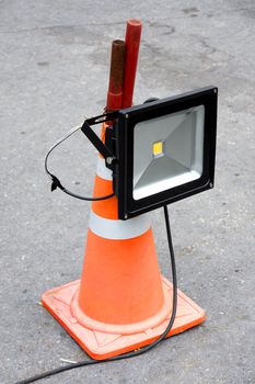 LED energy saving industrial flood light mounted on orange striped rubber cone
