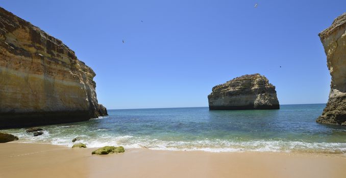 A beautiful empty golden sand beach in the Algarve region on the coast line Portugal