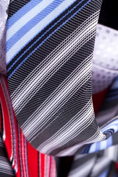 Close up detailed view of multicolored striped and checkered men ties as background.