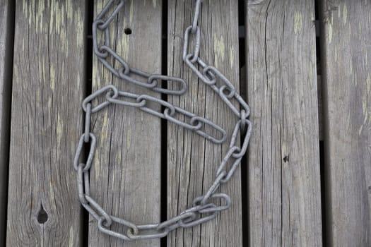 A wooden pier with grain and a chain on it