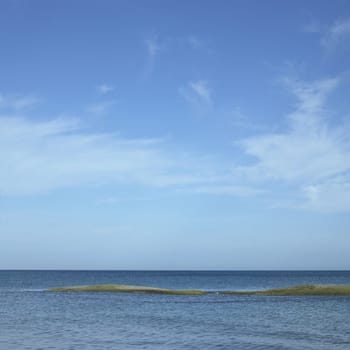 Top of a sandbar surrounded by blue ocean water