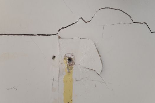 badly damaged interior plasterboard wall with drill holes