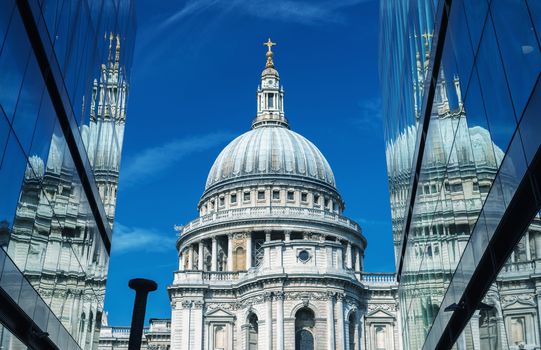 London. St Paul Cathedral reflected in modern glass on a beautiful summer day.