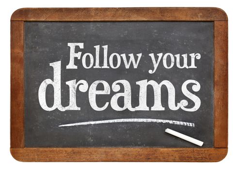 Follow your dreams motivational words - white chalk text on a vintage slate blackboard