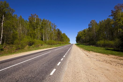   the small rural asphalted road photographed in summertime of year. Belarus