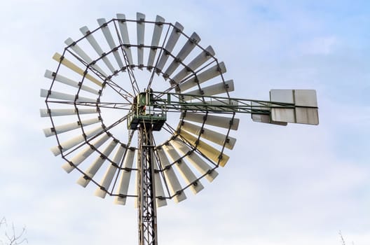  Historic Old Wind Wheell against a blue sky.