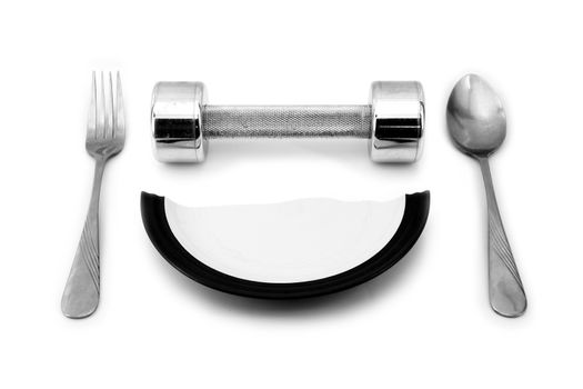 Dumbbell, a broken plate, fork, spoon to serve for breakfast. The concept of a healthy lifestyle, diet, sports, weight loss, exercise.