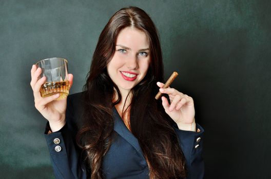 Young girl holding cigar and glass of whisky. Happy face expression, party style.