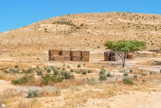 Desert landscape in Israel's Negev desert and bales of hay for animals.