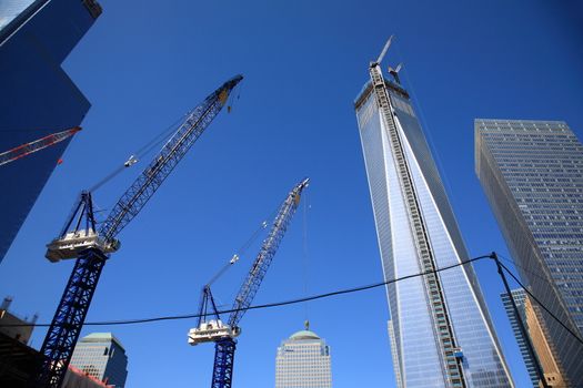 Construction cranes near rising Freedom Tower One World Trade Center in lower Manhattan.