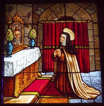 Saint Teresa Praying to Jesus Stained Glass Convento de Santa Teresa Basilica Avila Castile Spain.  Convent founded in 1636 for Saint Teresa, Catholic nun, Counterreformation author, and Spanish mystic, who founded the Carmelite order. Died in 1582 and made a saint in 1614.