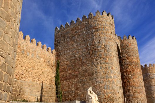 White Saint Teresa Statue Castle Walls Swallows Avila Castile Spain.  Avila described as the most 16th century town in Spain.  Saint Teresa Statue created 1972 by Juan Luis Vassallo Walls created in 1088 after Christians conquer  Moors  