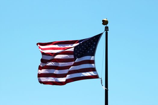 USA flag with a blue sky in the background.