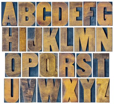 complete English alphabet - collage of 26 isolated vintage wood letterpress printing blocks, scratched and stained by ink patina