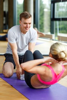 sport, fitness, lifestyle and people concept - smiling woman with male personal trainer exercising in gym