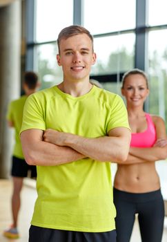 sport, fitness, lifestyle and people concept - smiling man and woman in gym